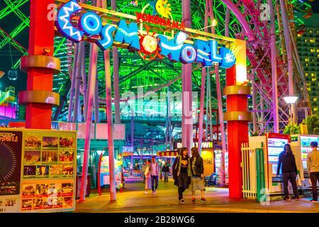 Yokohama, Japan - April 21, 2017: people at entrance and signboard of Cosmo World amusement park in Minato Mirai 21 district of Yokohama with Cosmo Stock Photo