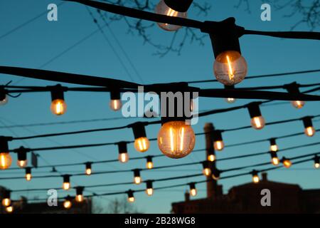 Light bulbs on the evening blue sky. Stock Photo