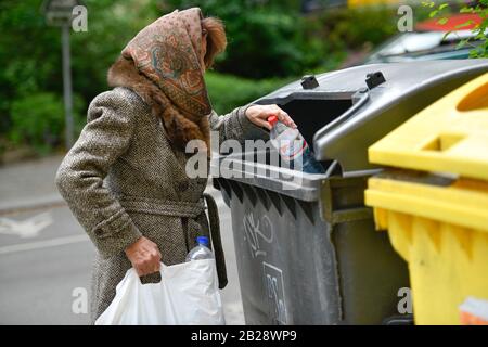 Gestelltes Symbolfoto, Altersarmut, Seniorin, Flaschensammeln, Mülleimer Stock Photo