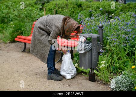Gestelltes Symbolfoto, Altersarmut, Seniorin, Flaschensammeln, Mülleimer, Park Stock Photo