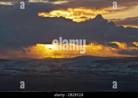 Winter sunset over the Ochil hills, which have a wind farm on their upper slopes. Stock Photo