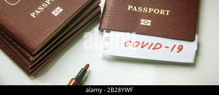Coronavirus and travel concept. Note COVID-19 coronavirus and passport. Novel corona virus outbreak. Spread of epidemic from China. Border control and Stock Photo
