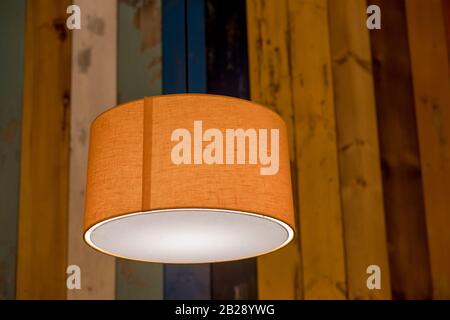 modern orange lamp with vintage light bulb.stylish lamps on wooden background.colorful wall, interior design for home, office, hotel and kitchen Stock Photo