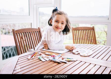 A girl paints some drawings with watercolor paint Stock Photo