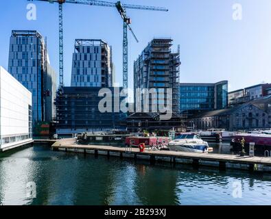 Grand Canal Dock houseboats in Grand Canal Dock, Dublin, Ireland, dwarfed by construction of the new Google offices at the Bolands Mills site. Stock Photo