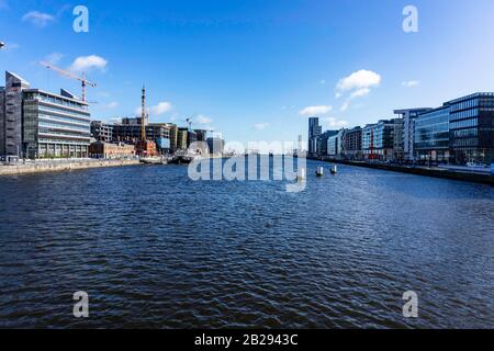 Dublin Docks, Ireland, being transformed with offices on either quayside and construction cranes busy at work. Stock Photo