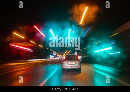 City colorful night lights perspective blurred by high speed of the car. A streak of light, trails. Stock Photo