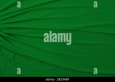 This soft flowing background texture features green fabric draped and taken from a top down view. Stock Photo