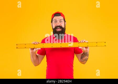 Perfect size. Bearded man with big measuring instrument. Measuring with ruler. Size measurement. Measuring length. Size clothes. Student study stem disciplines. Ruler tool equipment. Shop assistant. Stock Photo