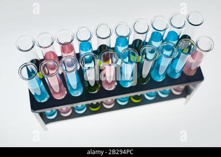 Above view background of test tubes with colored liquid on white table in medical laboratory, copy space Stock Photo