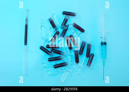 Top view background of syringe and blood samples on blue in medical laboratory, copy space Stock Photo
