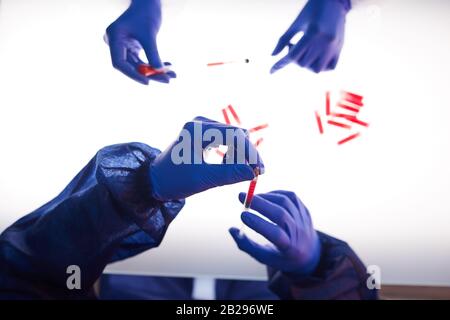 Top view background of two scientists examining blood samples over light panel in medical laboratory, copy space Stock Photo