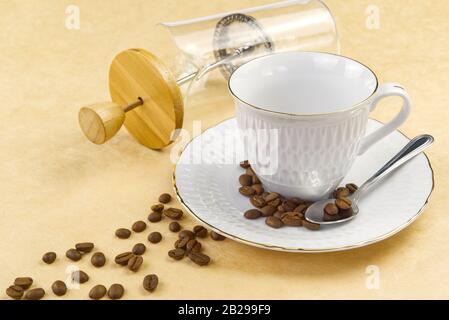 Empty white coffee cup with gold border and coffee seeds on the table. close up Stock Photo