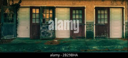 An Old Fashioned Three Door Garage With Big Red Doors and Broken Windows Stock Photo