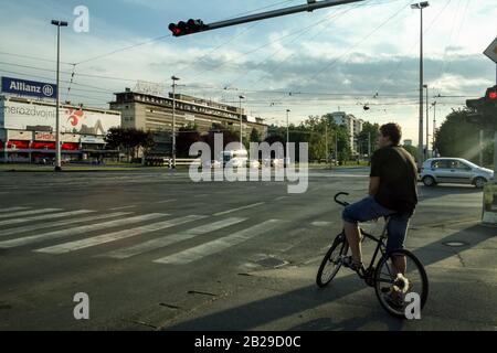 ZAGREB, CROATIA - JUNE 6, 2008: Cyclist waiting to cross Ulica Grada Vukovara street in Novi Zagreb, with heavy traffic. Novi Zagreb is the new part o Stock Photo