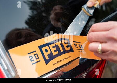 A Buttigieg supporter in Portland, Oregon removes the 'Pete 2020' bumper sticker from her car. Democratic presidential candidate Pete Buttigieg is announcing that he is quitting the race. The South Bend, Indiana mayor was unable to sustain his campaign efforts going in to Super Tuesday. Buttigieg was the first openly gay candidate from a major party to seek the nation's highest office. Stock Photo