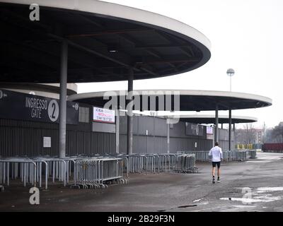 (200302) -- MILAN, March 2, 2020 (Xinhua) -- A man jogs outside the San Siro stadium after a Serie A soccer match between AC Milan and Genoa was postponed due to the recent coronavirus outbreak in Milan, Italy, March 1, 2020. The number of Italians infected by the coronavirus 'continues to accelerate,' Giovanni Rezza, head of the Italian High Institute of Health's Department of Infectious Diseases, said Sunday, adding that the country was at least a week away from seeing a peak in the outbreak. According to Angelo Borrelli, Civil Protection Department chief and Extraordinary Commissioner f Stock Photo