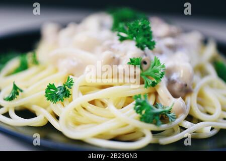 Close up spaghetti carbonara italian pasta served on white plate with parsley in the restaurant Stock Photo