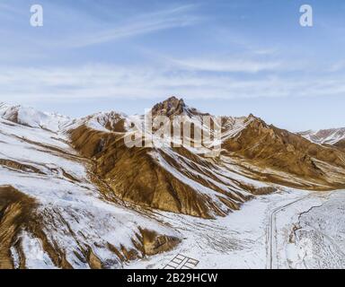 the gravel road on dry land with the snow mountain Stock Photo