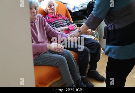 Altusried, Germany. 21st Feb, 2020. Ute Prinz (r) supports her 84-year-old mother Liselotte Lörmann (l), who suffers from dementia, in the dementia residential community. To live self-determinedly despite the illness is the aim of the community (to dpa-KORR: 'Here my mother can be a human being' - everyday life in a dementia shared flat'). Credit: Karl-Josef Hildenbrand/dpa - ATTENTION: Only for editorial use in connection with current reporting and only with complete mention of the above credit/dpa/Alamy Live News