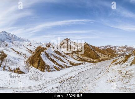 the gravel road on dry land with the snow mountain Stock Photo