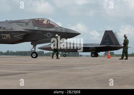 A U.S. Air Force F-22 Raptor taxis in front of U.S Marine Corps F-35B Lighting II before an aerial demonstration at the Singapore Airshow 2020 near the Changi Exhibition Center Feb. 12, 2020. The Singapore Airshow is a weeklong aviation event that draws in performers and fans from all around the world. (U.S. Air Force photo by 2nd Lt. Sam Eckholm). Stock Photo