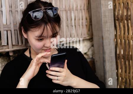 A young woman using her phone while relaxing Stock Photo