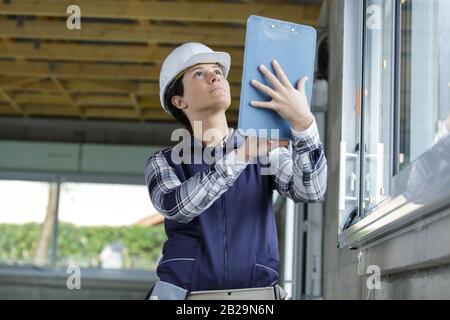 woman in helmet with clipboard in site Stock Photo