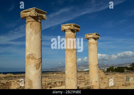 Ancient columns with ionic capitals against blue sky with clouds background. Salamis city ruins, Northen Cyprus. Stock Photo