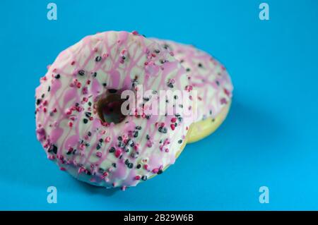 Donuts pink glazed on blue background. Closeup. Stock Photo