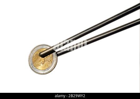 Metal chopsticks holding a Euro coin isolated on a white background Stock Photo