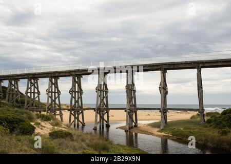 Gipplsand, Kilcunda Bourne Creek Trestle bridge on an overcast day with ocean in background Stock Photo