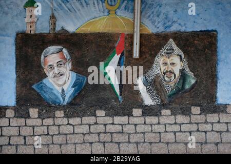 A wall with painted figures of Mahmoud Abbas the head of the Palestinian Authority and of Yasser Arafat who was a Palestinian political leader and Chairman of the PLO Palestine Liberation Organization in the city of Jericho West Bank Palestinian Authority territories Stock Photo