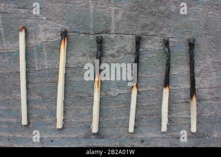 Burnout syndrome concept. Burned matches on a rough wooden background. Top view. Copy space