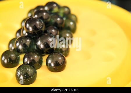 Single glass green marble ball with a nice shadow and impressive light with blur background Stock Photo