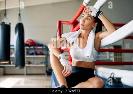 Young beautiful woman relax after fight or workout exercising in boxing ring. Sport concept Stock Photo