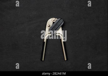 Safe modern can opener on a black background. Equipment for opening cans. Flat lay. Copy space. Black minimalist. Stock Photo