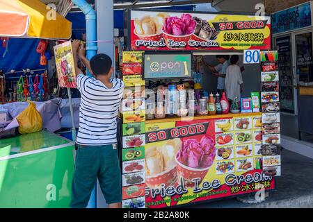 A man secures the parasol of his "Fried Ice Cream" Stall, Thailand Stock Photo