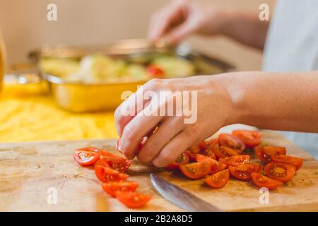 Chopping cherry tomatoes on a cutting board Stock Photo