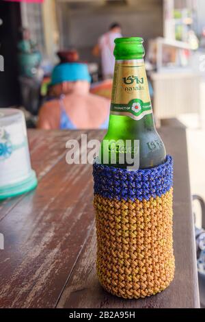 Bottle of Chang Thai Beer with a knitted insulated jacket to keep it cold, Thailand. Stock Photo