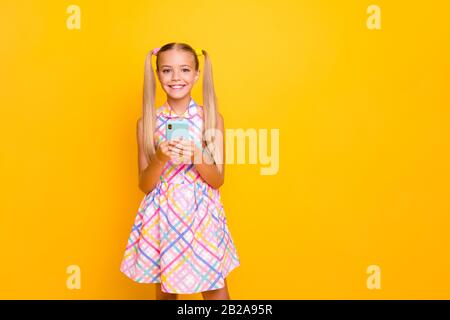 Photo of beautiful pretty little lady hold telephone young influencer write new post for own popular school theme blog wear checkered sun dress Stock Photo