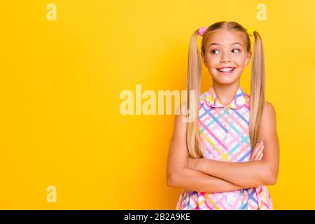 Photo of funny small lady arms crossed good mood look playful side empty space wear checkered plaid summer dress isolated yellow shine color Stock Photo