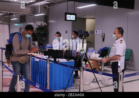 Air passenger wearing a face mask going through the Thermoscan at Suvarnabhumi Airport during the Coronavirus epidemic. Bangkok Thailand. © Kraig Lieb Stock Photo