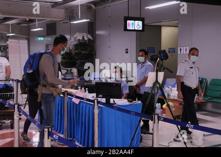 Air passengers wearing face masks go through the Thermoscan at Suvarnabhumi Airport during the Coronavirus epidemic. Bangkok Thailand. © Kraig Lieb Stock Photo