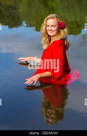 Portrait young blonde european woman standing in natural water Stock Photo