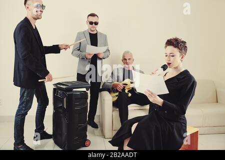 Music band practicing new song at rehearsal in studio Stock Photo