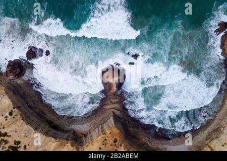 Aerial drone photo of the waves crashing against the rocks in the beautiful coastline along the Vicentine Coast, near the Bordeira Beach, in Algarve, Stock Photo