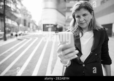 Mature businesswoman exploring the city of Bangkok, Thailand Stock Photo