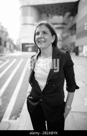 Mature businesswoman exploring the city of Bangkok, Thailand Stock Photo