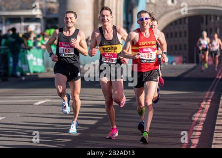 Club runners racing in the Vitality Big Half half marathon crossing Tower Bridge, London, UK. Dougie Musson, 192, George King, 278, Will Green, 199 Stock Photo